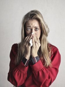 photo of woman in red long sleeve shirt who has a cold or flu
