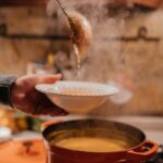 a person getting a bowl of hot soup