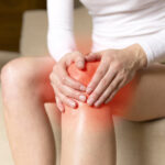 woman holding her painful knee