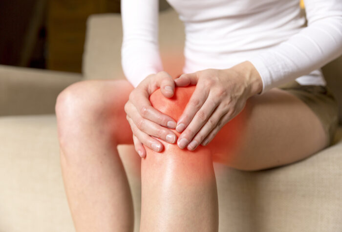 woman holding her painful knee